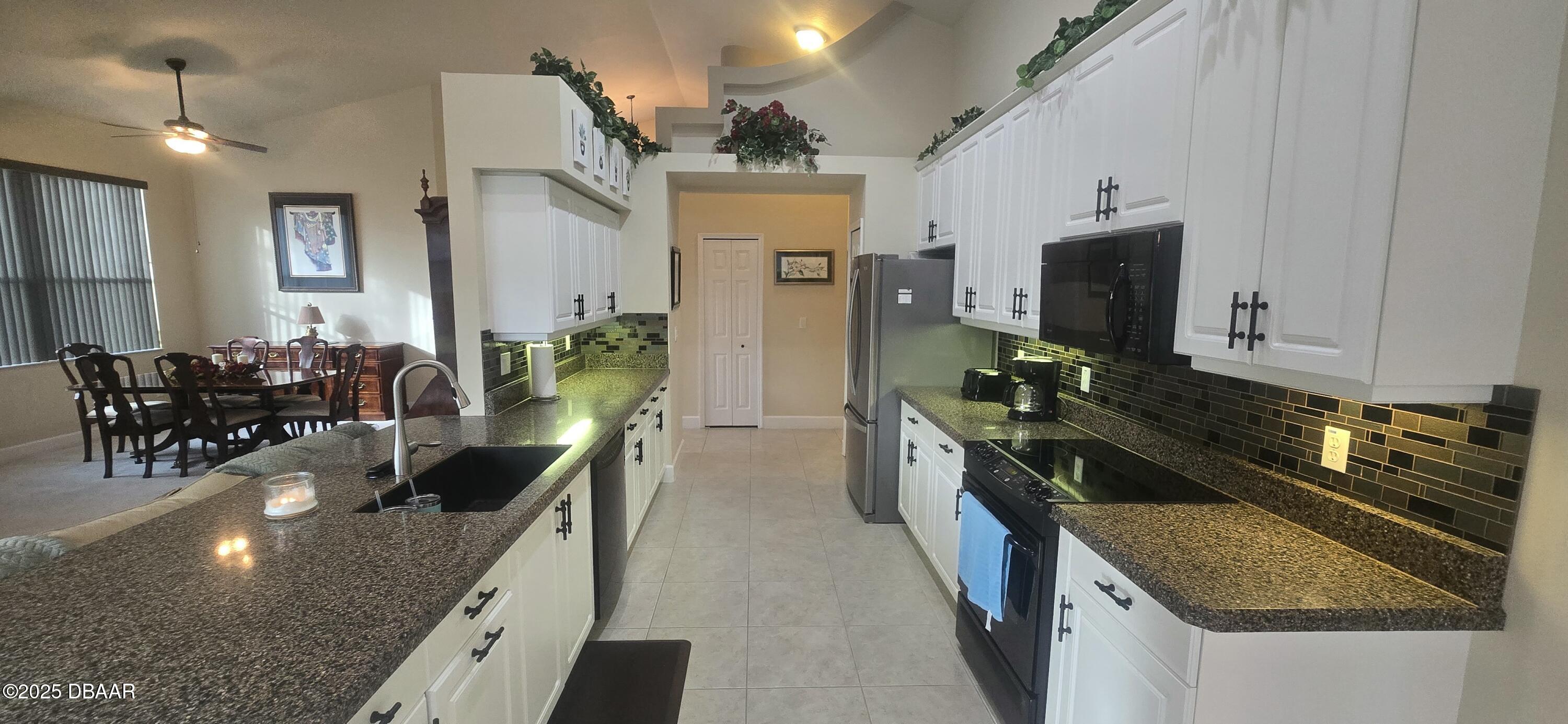 1279 Royal Pointe Lane Ormond Beach, FL 32174 - Photo 7 of 24 a kitchen with stainless steel appliances granite countertop a sink stove and refrigerator