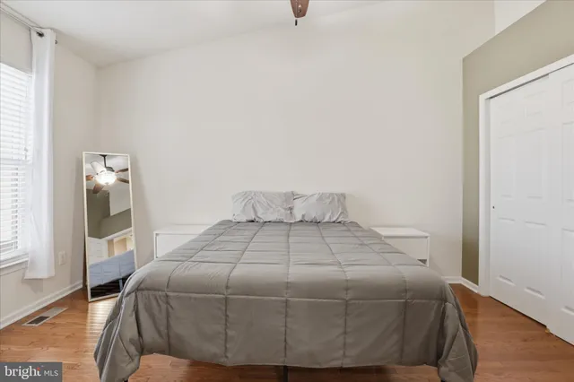 a bedroom with a bed and wooden floor