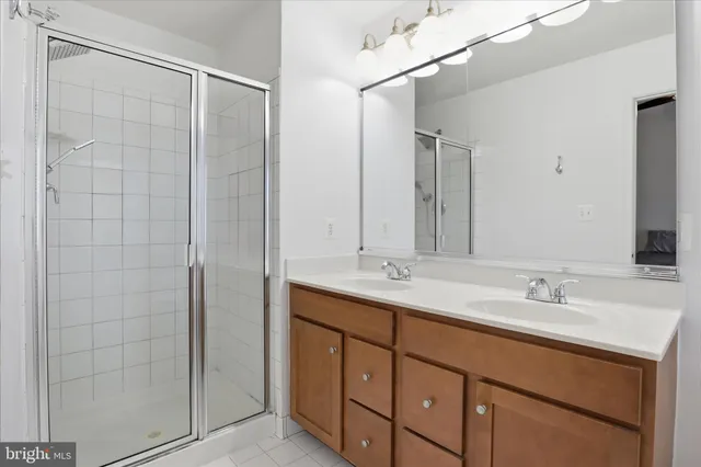 a bathroom with a double vanity sink a mirror and shower