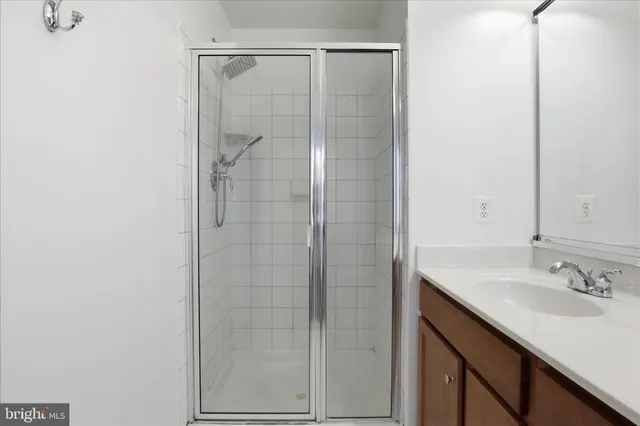 a bathroom with a shower sink vanity and mirror