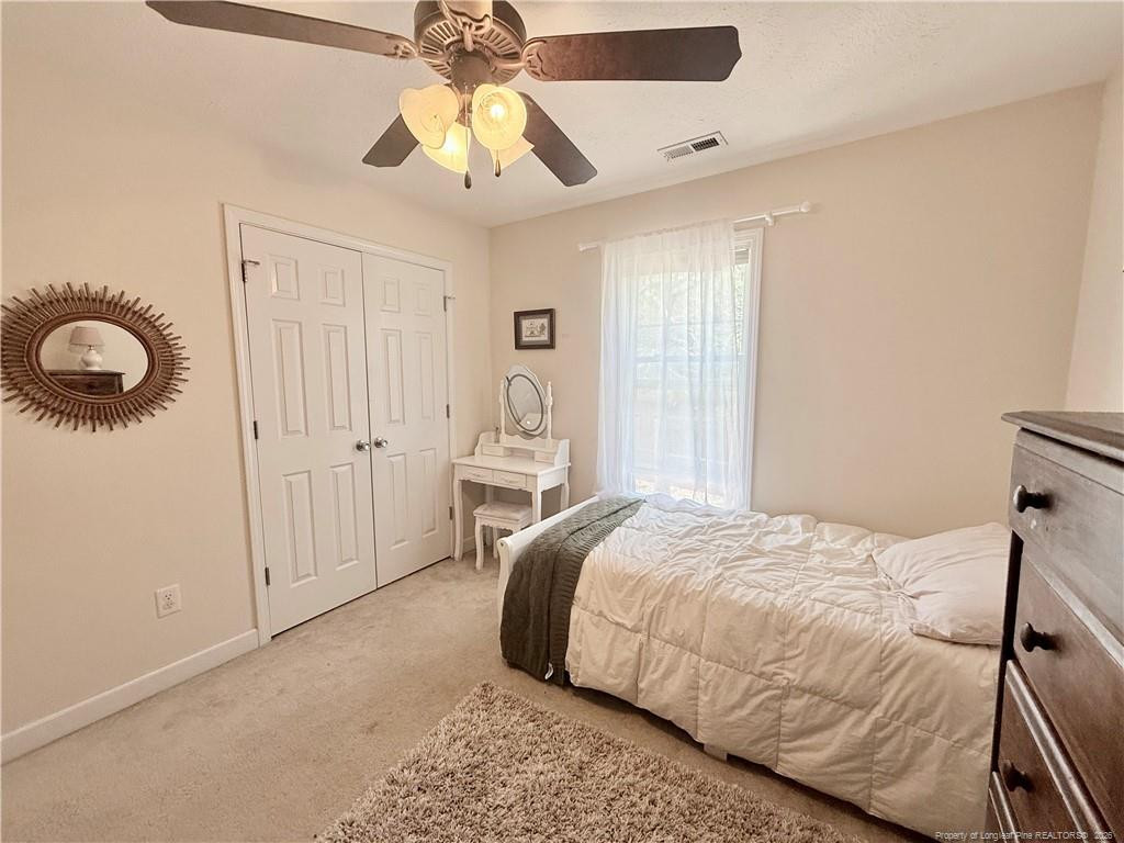234 Pender Road Spring Lake, NC 28390 - Photo 33 of 39 a bedroom with a bed and a chandelier