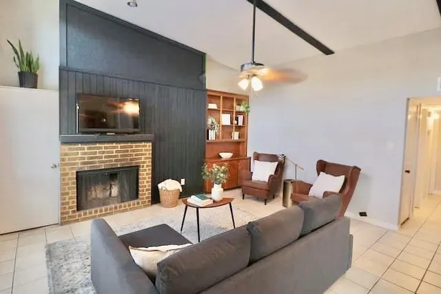 a living room with furniture a flat screen tv and a fireplace