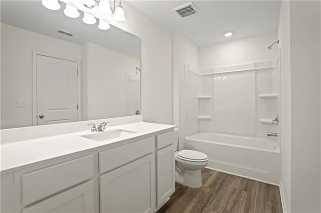 a bathroom with a sink a toilet and a large mirror