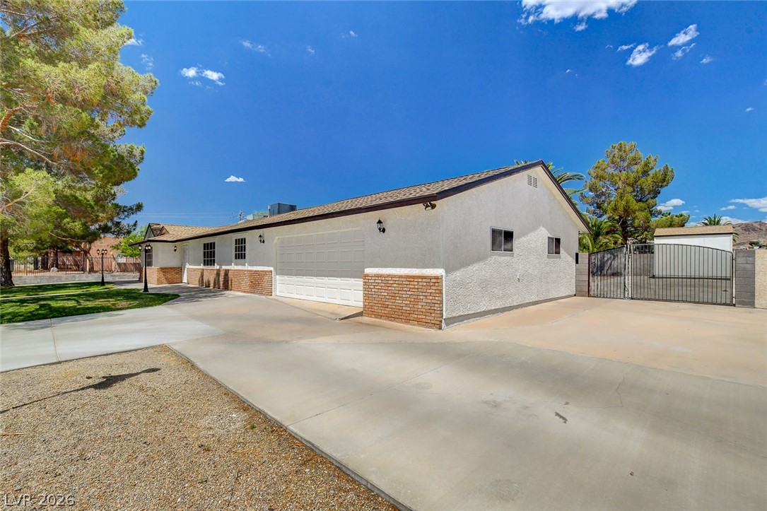 1810 Pinto Road Henderson, NV 89002 - Photo 8 of 53 A classic ranch-style home with a long driveway and a spacious garage offers ample parking and curb appeal.