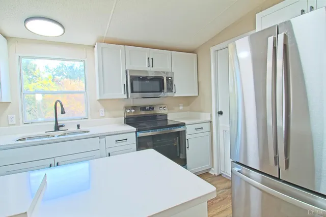 a kitchen with appliances a sink and cabinets