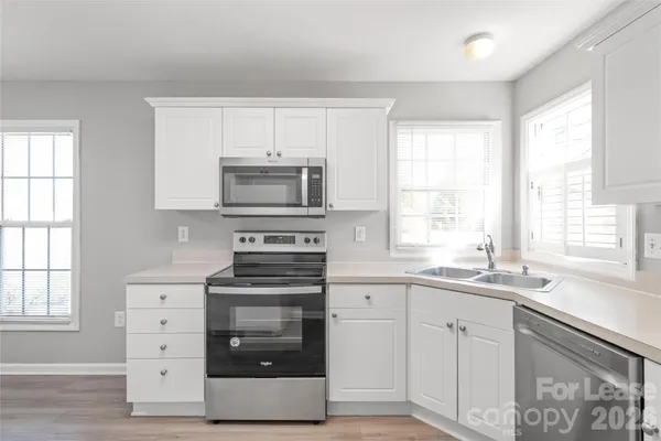 a kitchen with white cabinets and appliances