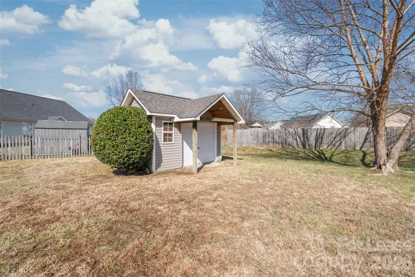 a view of a house with a yard and large tree