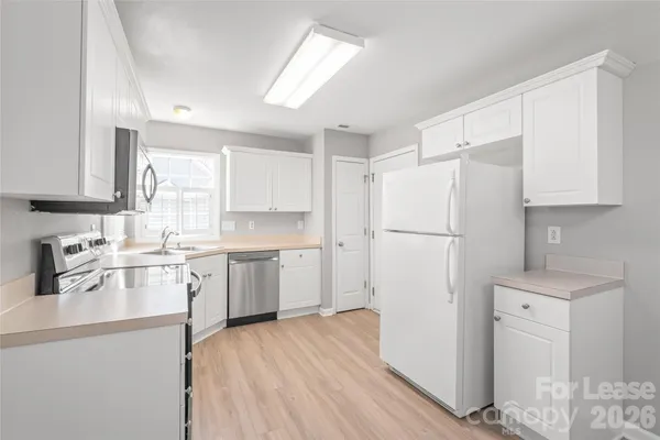 a kitchen with a refrigerator a sink and cabinets