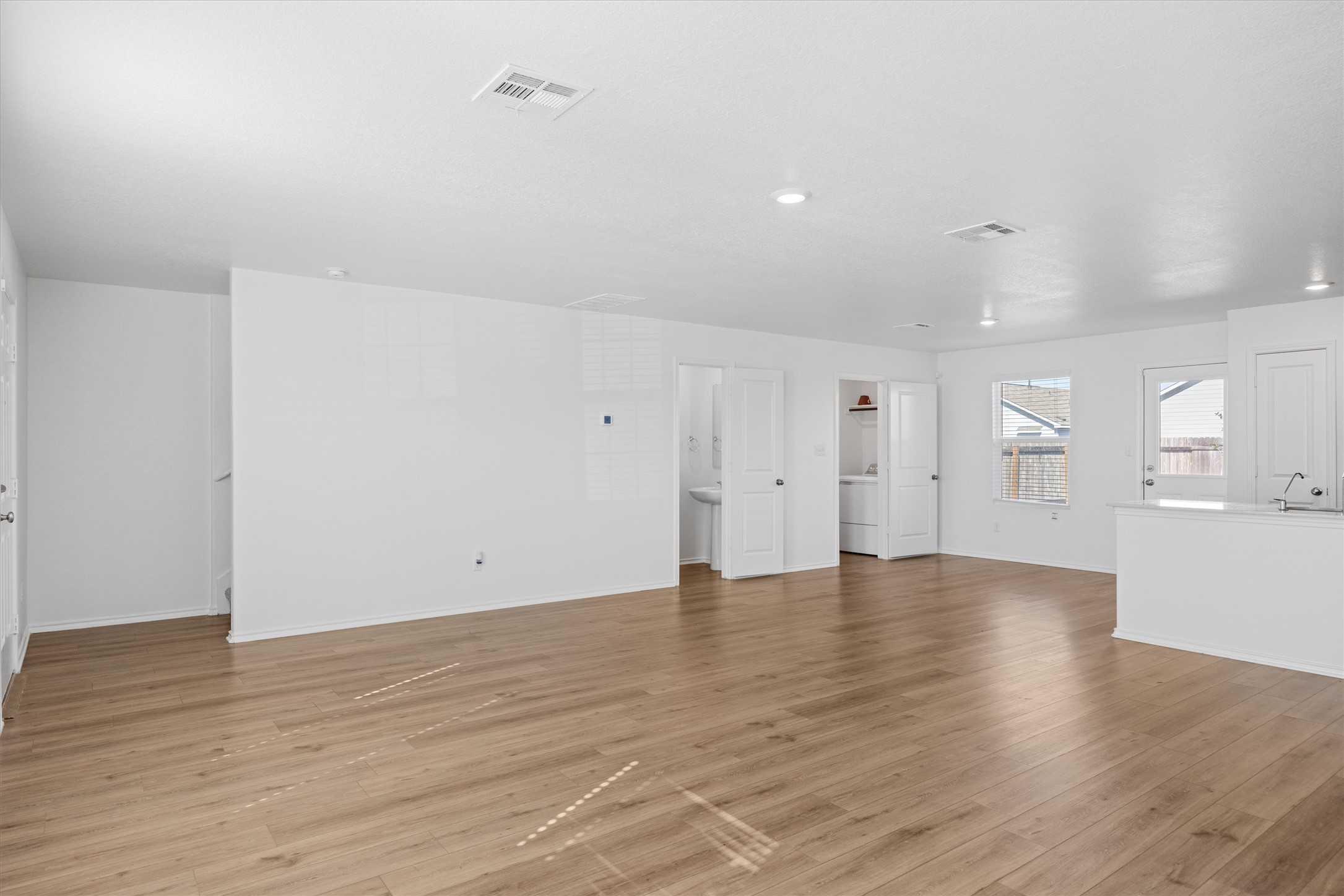 13520 Knights Branch Drive Elgin, TX 78621 - Photo 4 of 20 Unfurnished living room featuring wood-style vinyl flooring and recessed lighting.