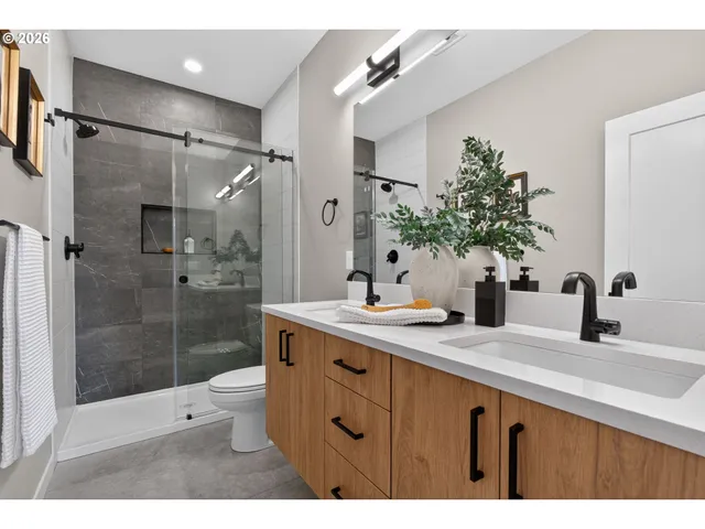a bathroom with a shower sink vanity granite and a shower