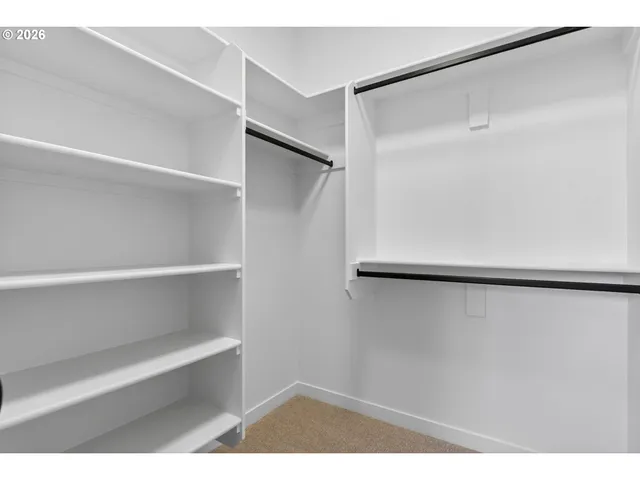 a view of walk in closet with empty racks