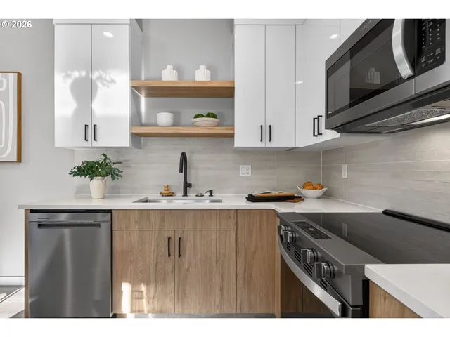 a kitchen with stainless steel appliances a sink a stove and cabinets