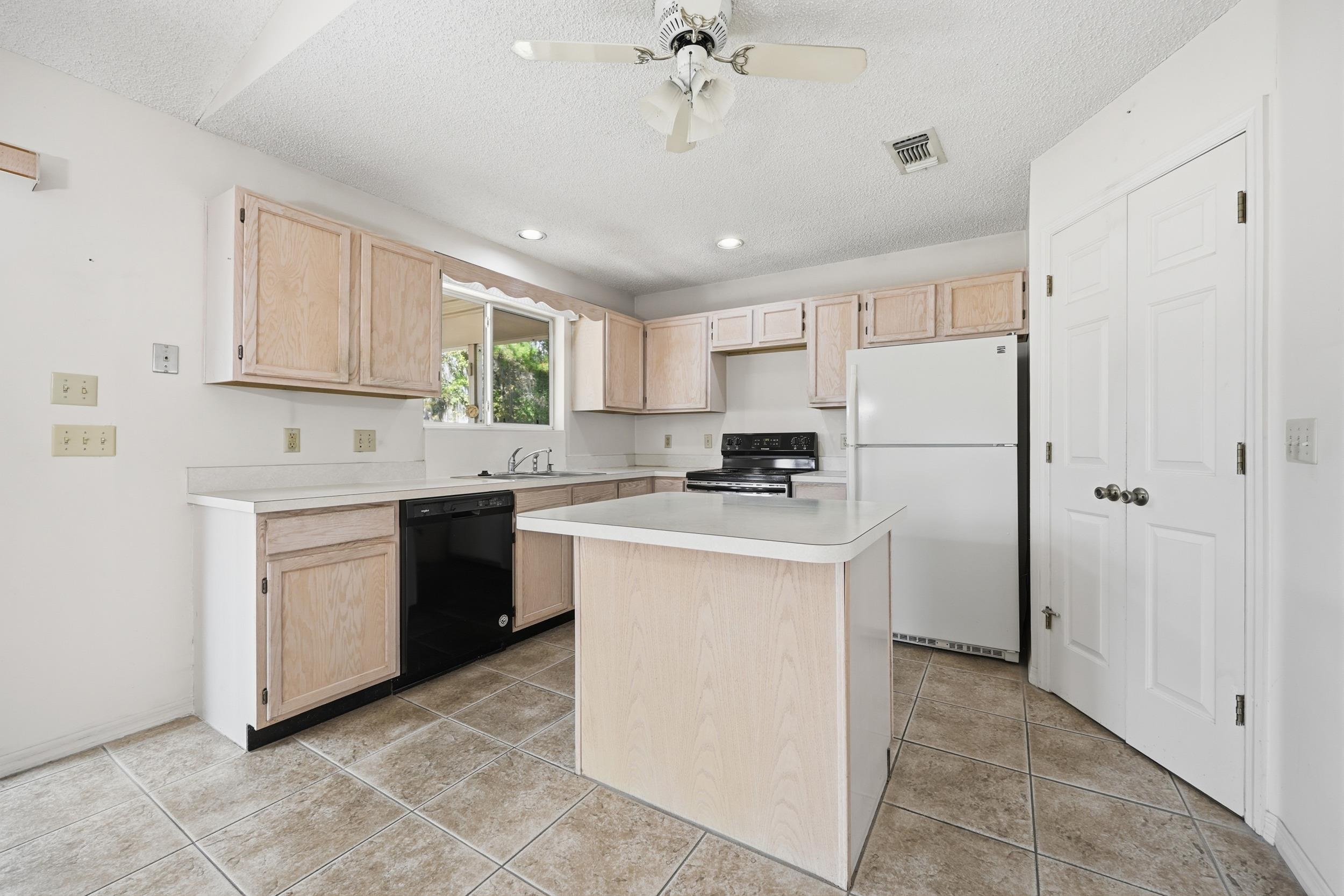 4628 Legends Lane Elkton, FL 32033 - Photo 11 of 49 Kitchen featuring light brown cabinets, black appliances, light countertops, a textured ceiling, and recessed lighting