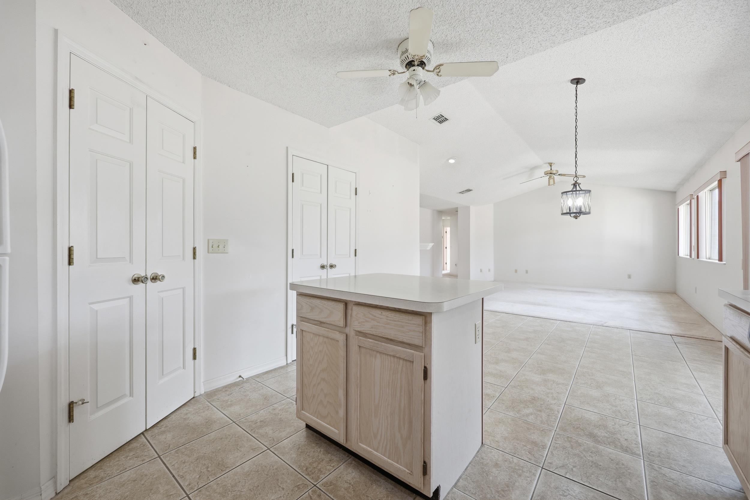 4628 Legends Lane Elkton, FL 32033 - Photo 13 of 49 Kitchen featuring light brown cabinetry, a ceiling fan, lofted ceiling, light countertops, and light tile patterned floors