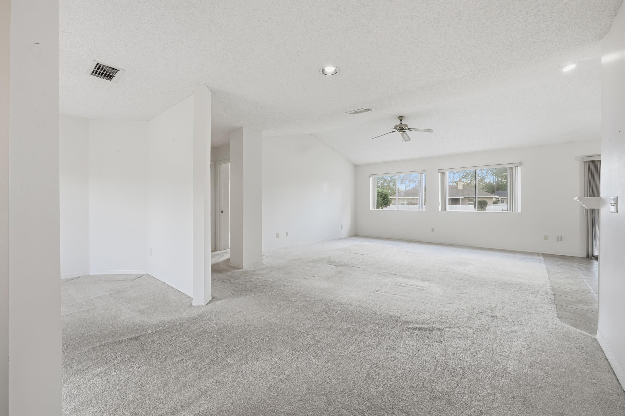 4628 Legends Lane Elkton, FL 32033 - Photo 3 of 49 Unfurnished living room with ceiling fan, light carpet, vaulted ceiling, recessed lighting, and a textured ceiling