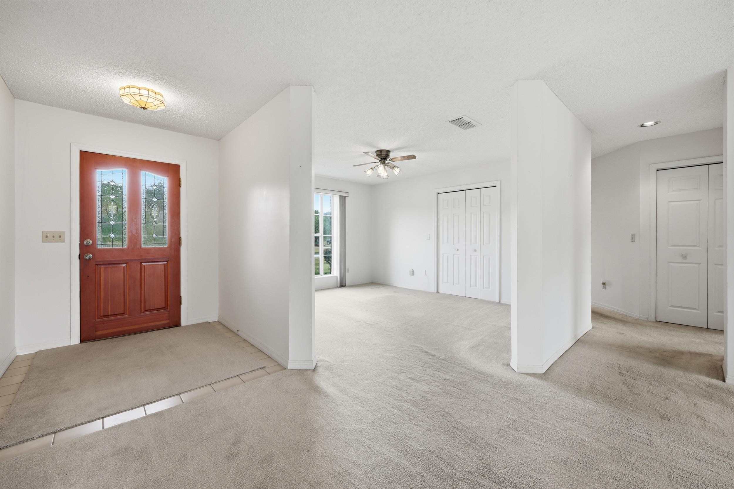 4628 Legends Lane Elkton, FL 32033 - Photo 4 of 49 Entryway featuring light carpet, ceiling fan, and a textured ceiling