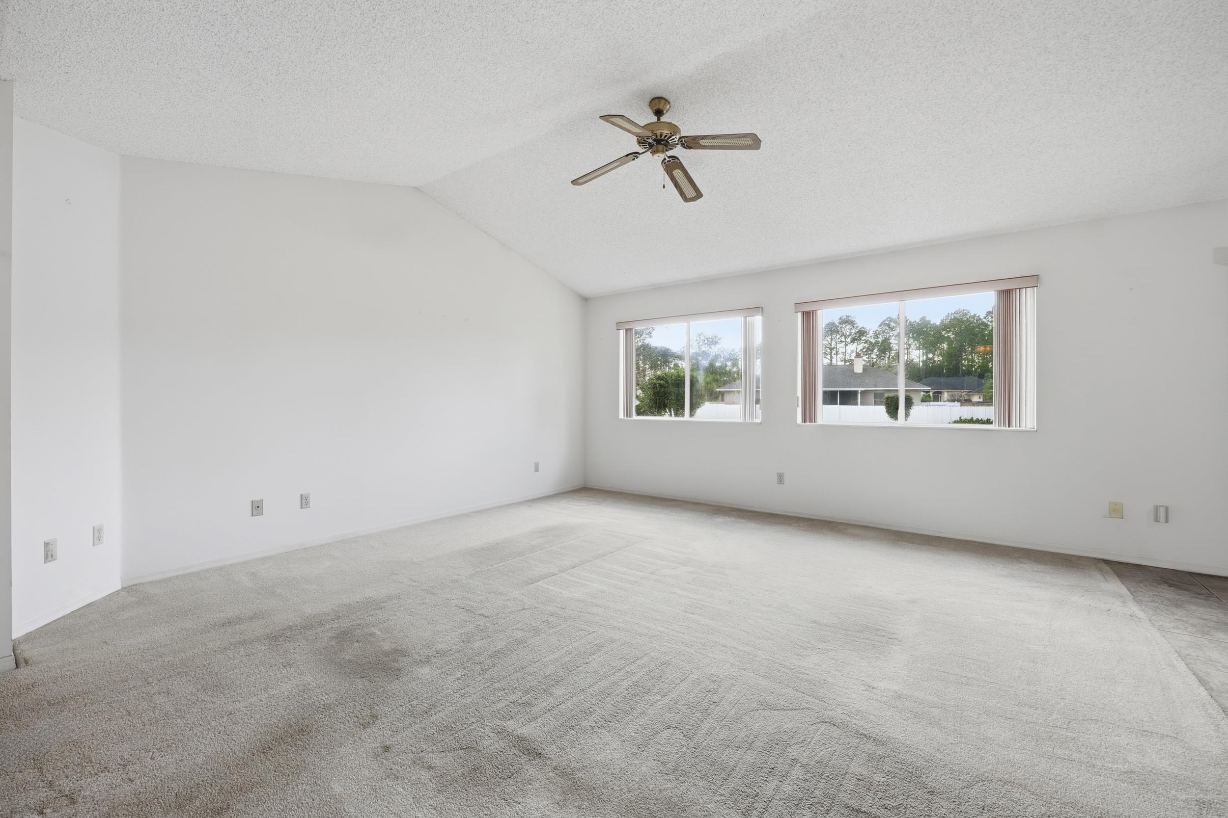 4628 Legends Lane Elkton, FL 32033 - Photo 6 of 49 Carpeted empty room with lofted ceiling, a ceiling fan, and a textured ceiling