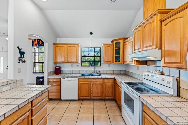 a kitchen with a sink stove top oven and cabinets