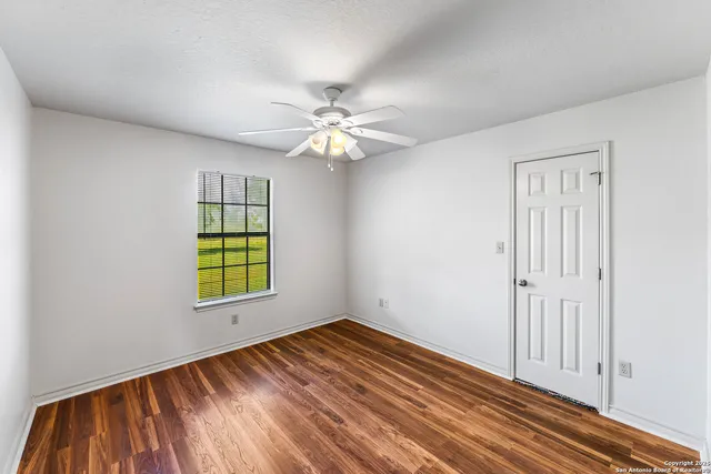 wooden floor in an empty room with a window