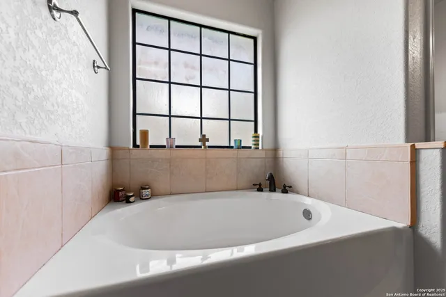 a bathroom with a bathtub and next to a window