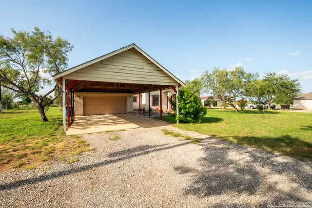 a view of a house with backyard and trees