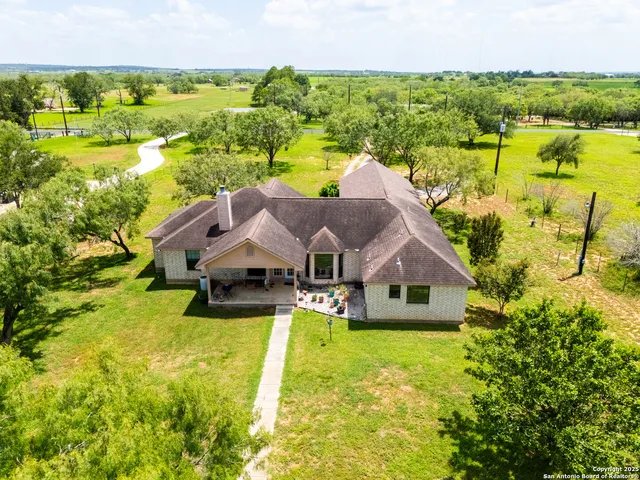 a view of a house with pool and a yard with lawn chairs