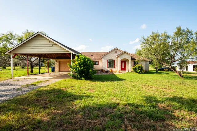 a yellow and red house sitting in middle of the garden