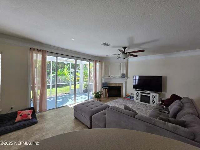 a living room with furniture a flat screen tv and a fireplace