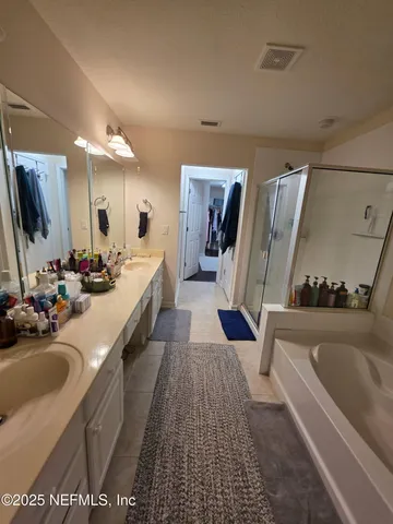 a bathroom with a tub sink and mirror