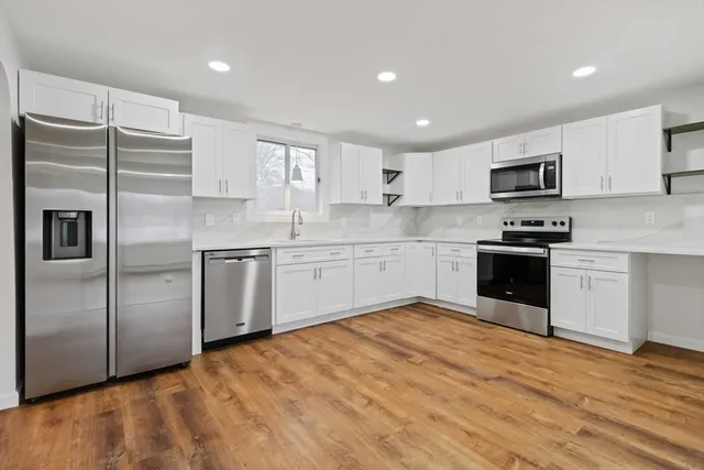 a kitchen with cabinets stainless steel appliances and a window