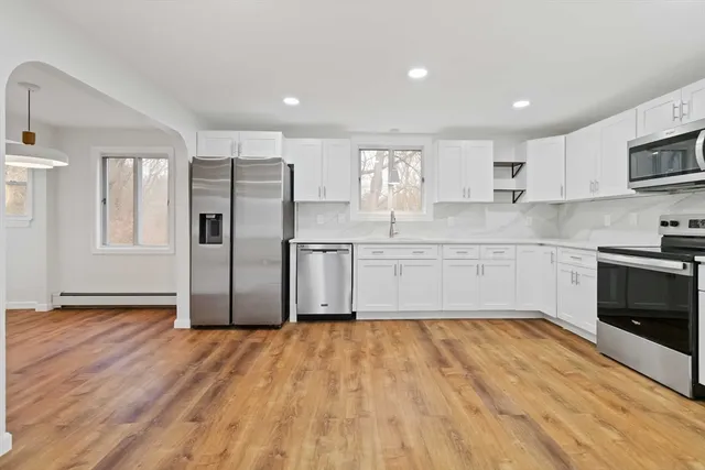 a kitchen with stainless steel appliances granite countertop a stove a sink and a refrigerator