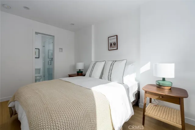 a bedroom with a bed and wooden floor