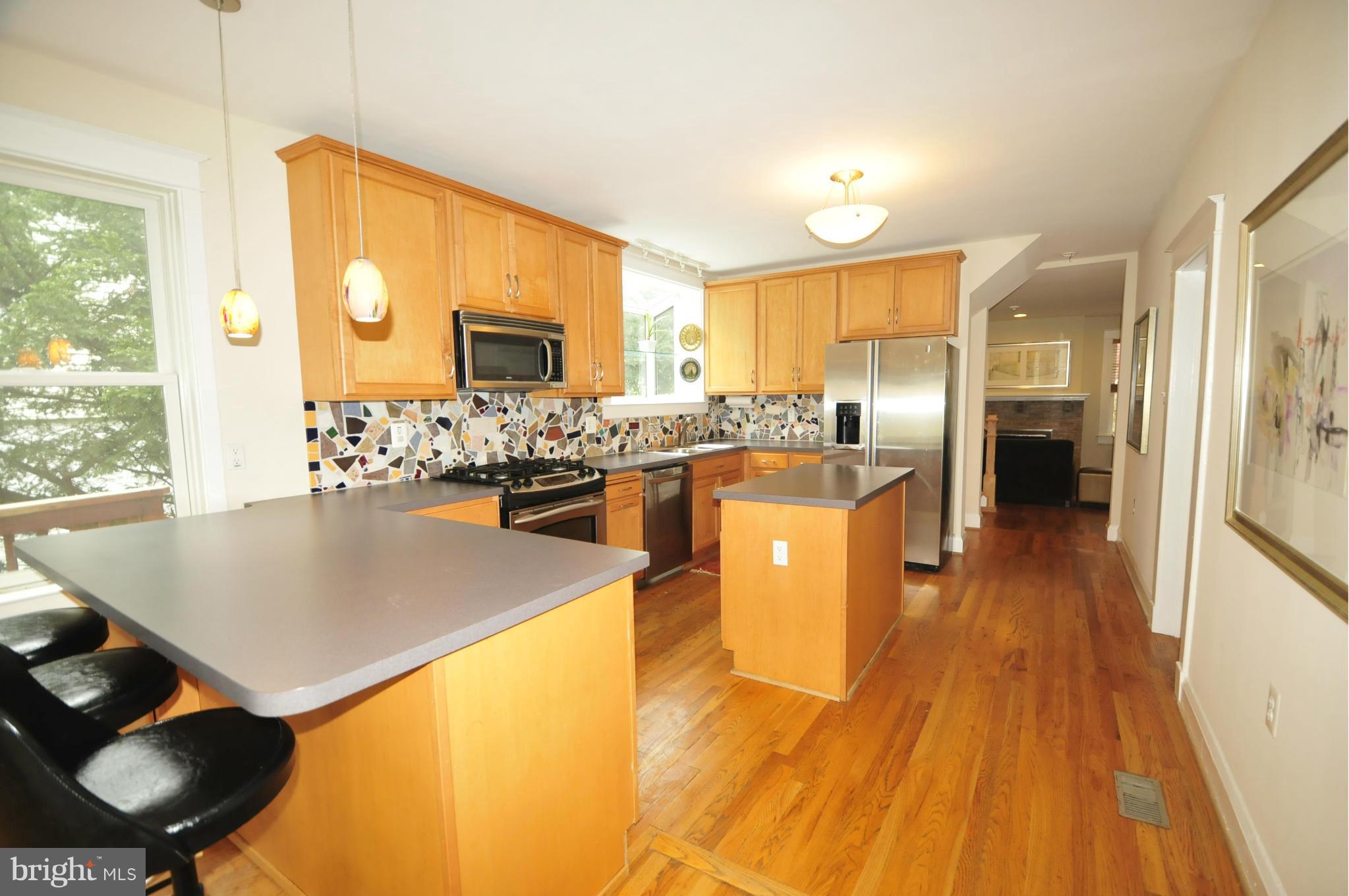 1825 Fairbank Road Baltimore, MD 21209 - Photo 9 of 27 a kitchen with stainless steel appliances granite countertop a stove top oven a sink dishwasher and a refrigerator with wooden floor