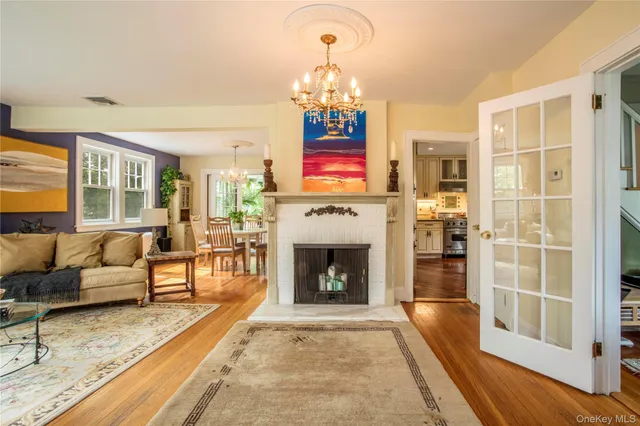 a living room with furniture a fireplace and a chandelier