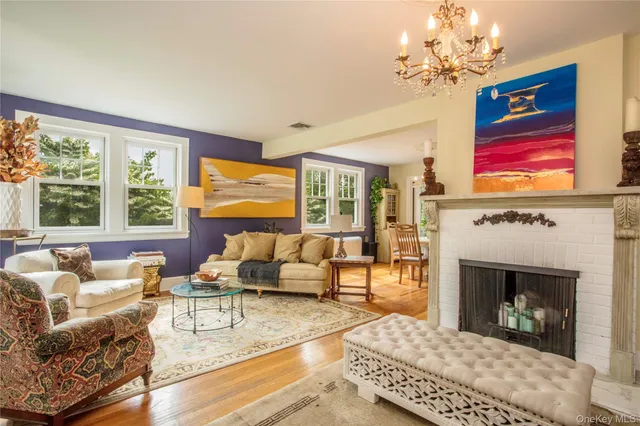 a living room with furniture a chandelier and a fireplace