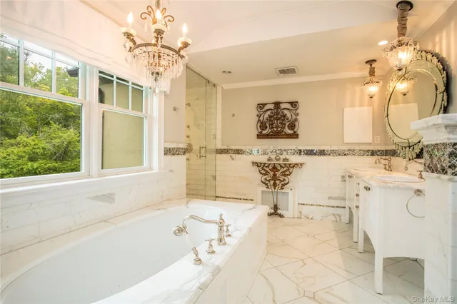 a bathroom with a tub sink and mirror