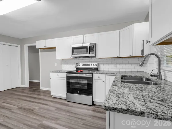 a kitchen with stainless steel appliances granite countertop a stove and a sink