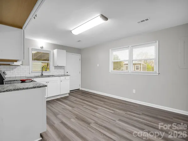 a kitchen with a cabinets wooden floor and a window