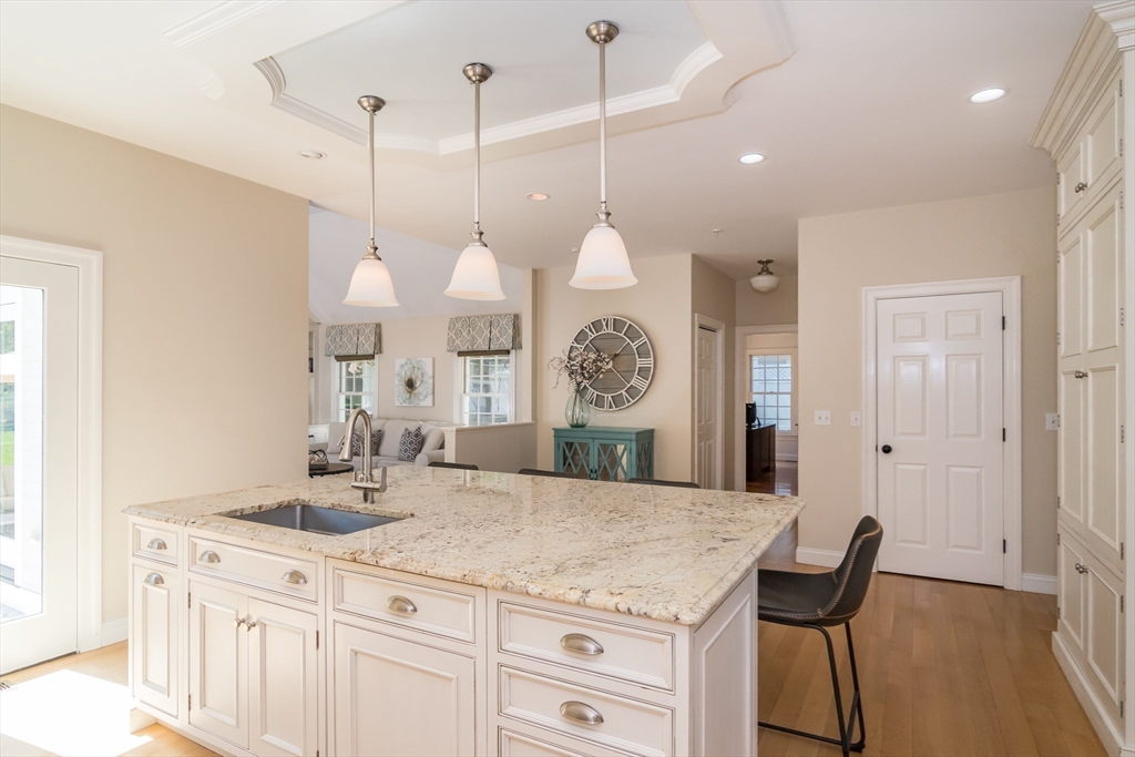 227 Concord Road Wayland, MA 01778 - Photo 8 of 20 a kitchen with a table chairs and a chandelier
