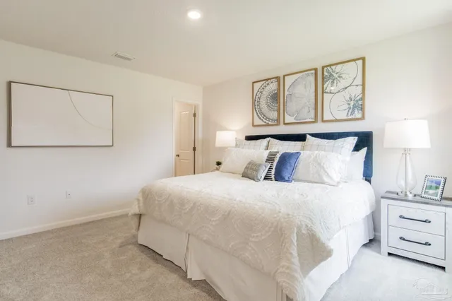 a bedroom with a bed and painting on the wall