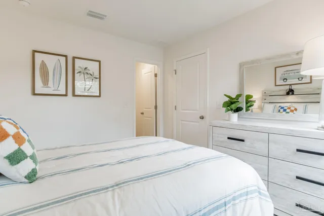a bedroom with a bed potted plant and cabinets