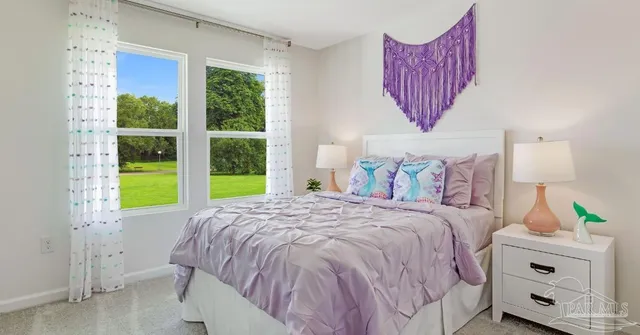 a bed sitting in a bedroom next to a window