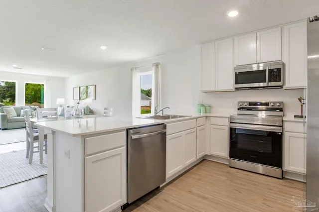 a kitchen with stainless steel appliances granite countertop a sink stove and microwave
