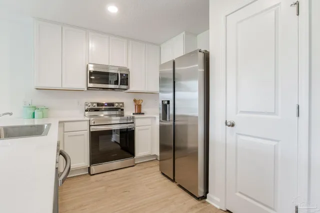 a kitchen with stainless steel appliances a refrigerator stove and microwave