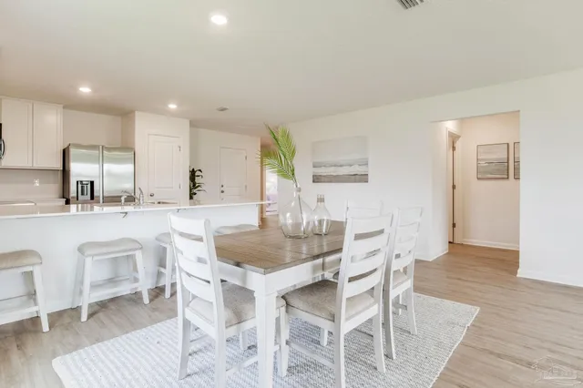 a kitchen with a dining table chairs and white cabinets
