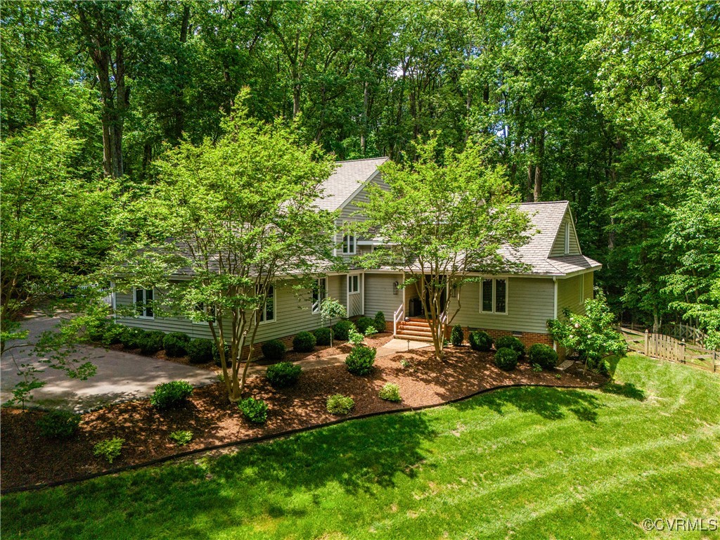 a view of a backyard with table and chairs potted plants and large tree