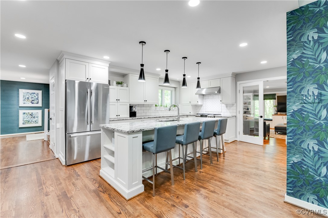 3510 Lansdowne Road Midlothian, VA 23113 - Photo 19 of 47 a kitchen with stainless steel appliances granite countertop a refrigerator a stove top oven and a dining table with wooden floor