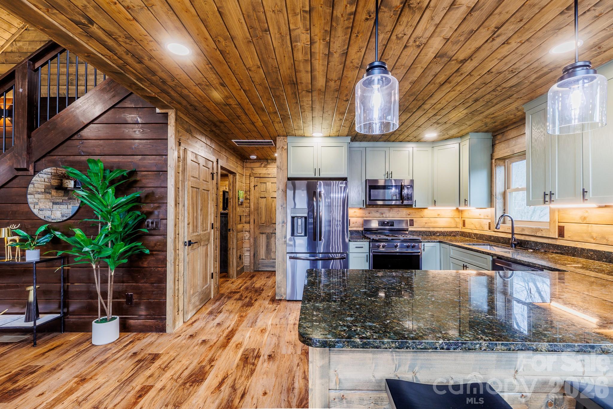 601 Tater Patch Road Maggie Valley, NC 28751 - Photo 14 of 32 a kitchen with lots of counter top space and wooden floor
