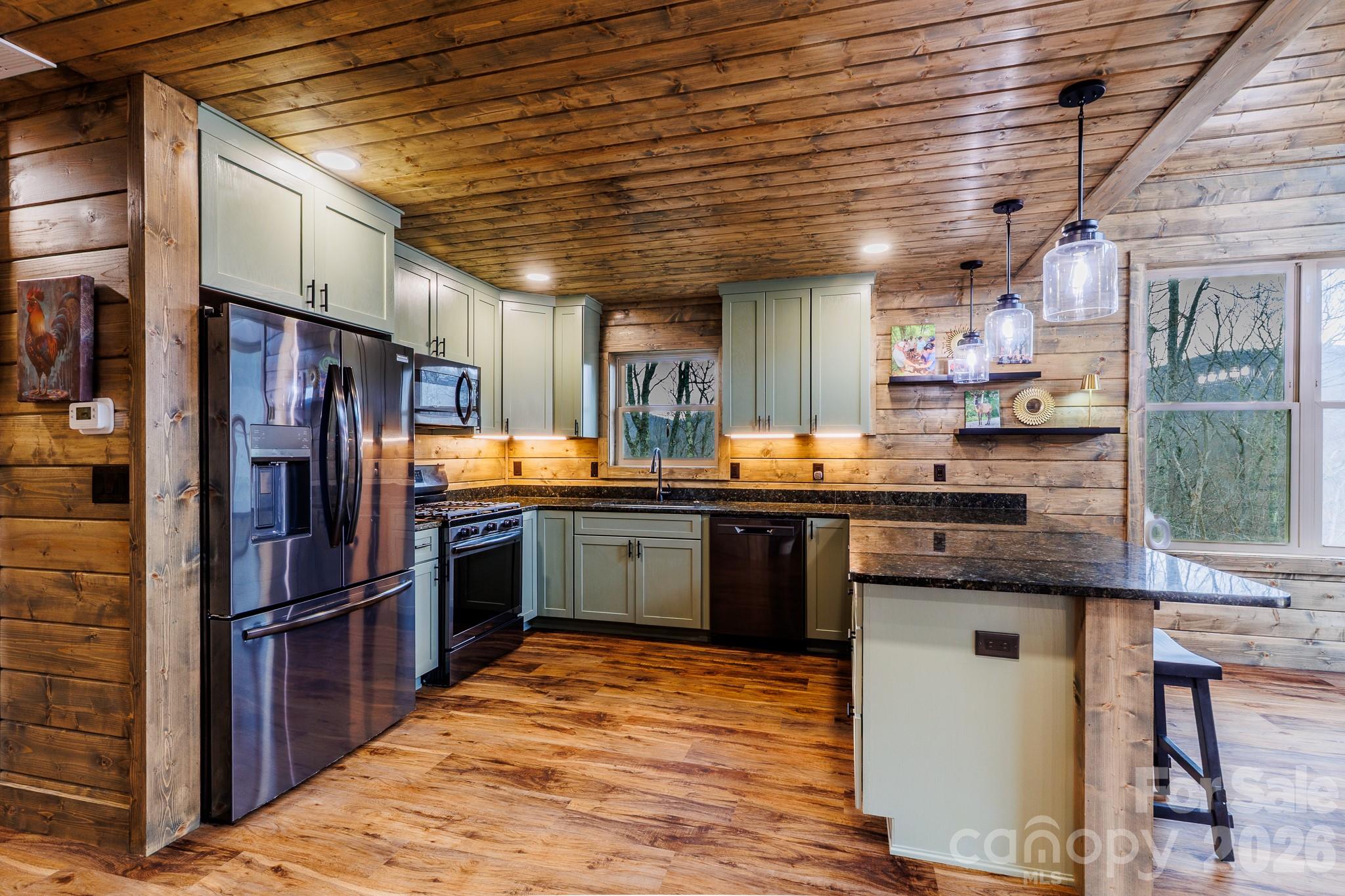 601 Tater Patch Road Maggie Valley, NC 28751 - Photo 15 of 32 a kitchen with stainless steel appliances granite countertop a refrigerator and wooden cabinets