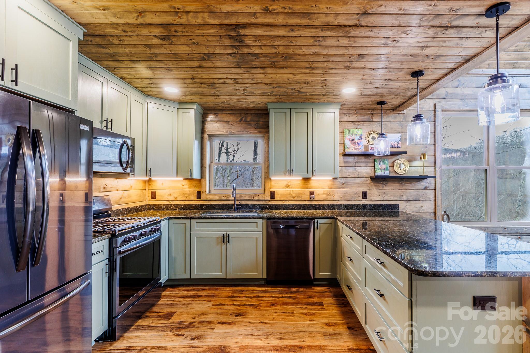 601 Tater Patch Road Maggie Valley, NC 28751 - Photo 16 of 32 a kitchen with stainless steel appliances granite countertop a sink a stove a refrigerator and cabinets